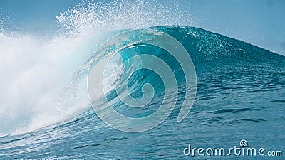 CLOSE UP: Glassy droplets of ocean water fly away from spectacular tube wave. Stock Photo