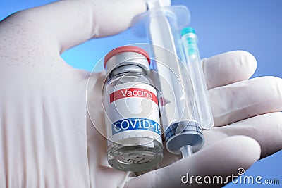 close up of gloved hand holding coronavirus vaccine vial, syringe and needle Stock Photo