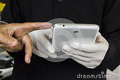 Gloved hand uses tablet on his black shirt and finger of old person showing Stock Photo