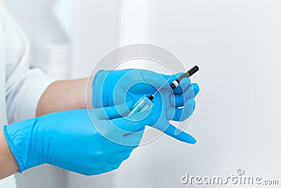 Close-up of a gloved nurse taking a sterile needle from a package Stock Photo