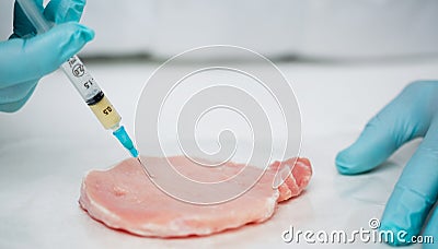 Close up of gloved researchers hands injecting meat Stock Photo