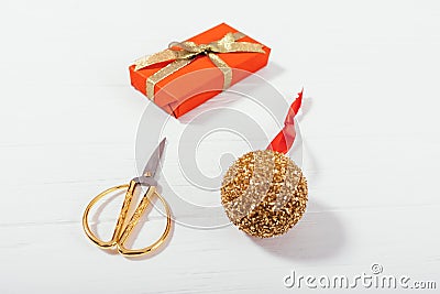 Close-up gold Christmas ball, scissors and red gift box Stock Photo