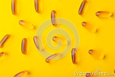 Close-up gold fish oil softgel fatty acid capsules scattered Stock Photo