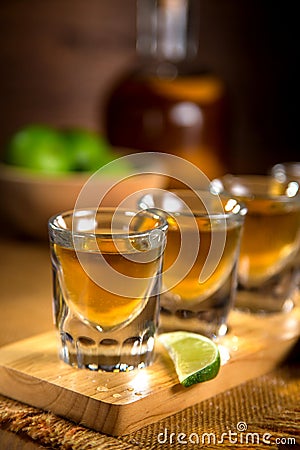 Close up of gold Tequila shots flight with cut limes and salt Stock Photo