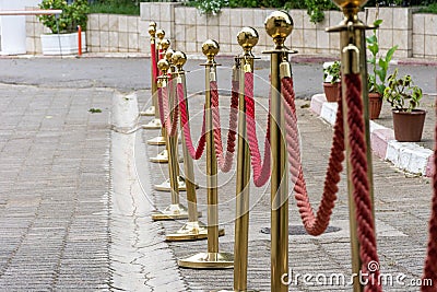 Close up of golden barriers with red rope. Stock Photo