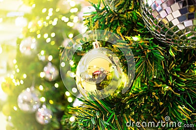 Close up. A golden gift hang on chrismas tree. Blurred background Stock Photo