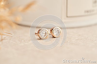 Close up golden stud earrings, with white crystals and diamonds. Beautiful earrings on white background. Stock Photo