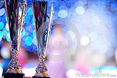 Close-up of golden trophies lined up at a dance event. Collection of trophies. Award cups closeup with space for text on Stock Photo