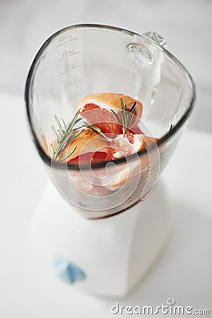 Close up of grapefruit pieces and rosemary in blender. Healthy fitness diet nutrition. Stock Photo