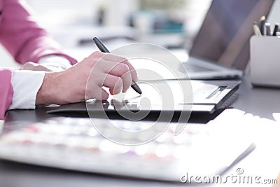Close up. a graphic designer uses a graphics tablet sitting at D Stock Photo
