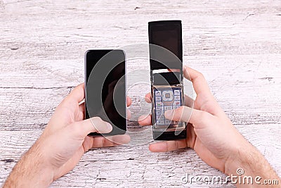 Close up on a gray background in two hands two phones Stock Photo