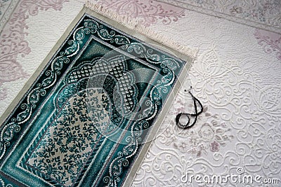 Close-up green prayer rug and rosary, praying in the month of ramadan Stock Photo