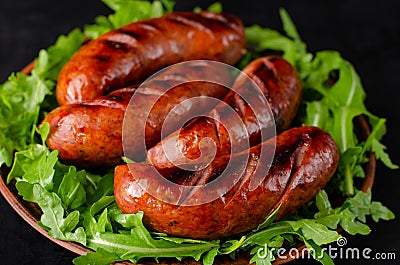 Close up of grilled sausages and arugula on black Stock Photo