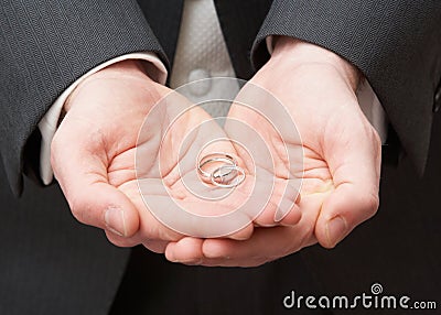 Close Up Of Groom Holding Wedding Rings Stock Photo