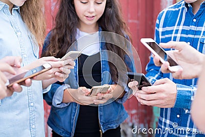 Close Up Of Group Of Teenage Friends Looking At Mobile Phones In Stock Photo