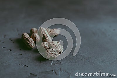 A close-up of a group of whole unpeeled dried peanuts in shell Stock Photo
