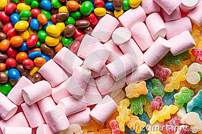 Close-up of gummies, colored chocolate balls and marshmallows placed in three diagonal lines occupying the entire horizontal image Stock Photo