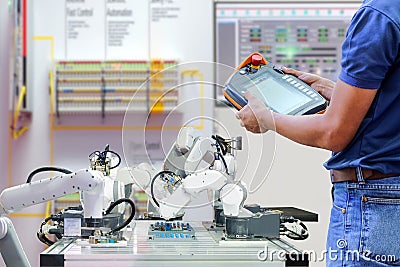 Close-up half body part of technician who using wireless remote to setting program for control robotic to work Stock Photo