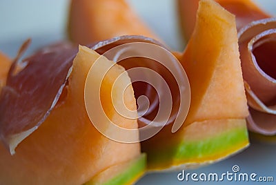Close-up of ham and slides of orange melon Stock Photo