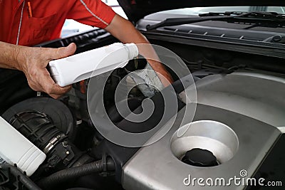 Close up hand adding fresh oil into engine car, repairing change the oil. Car maintenance at service station. Stock Photo