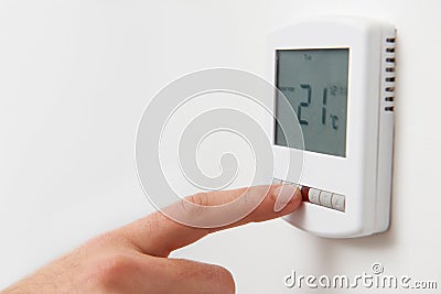 Close Up Of Hand Adjusting Digital Central Heating Thermostat Co Stock Photo