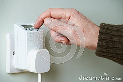 Close Up Of Hand Adjusting Timer Switch In Plug Socket Stock Photo