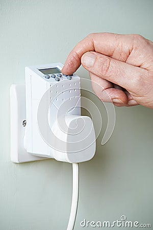 Close Up Of Hand Adjusting Timer Switch In Plug Socket Stock Photo