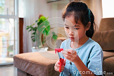Close up on hand of asian child girl enjoy making artwork and craft at home. Stock Photo
