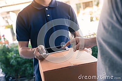 Close up of hand asian man using smartphone pressing screen to sign for delivery from the courier at home Stock Photo