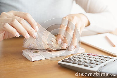 Close-up hand of asian woman using calculator counting and count money in home Stock Photo