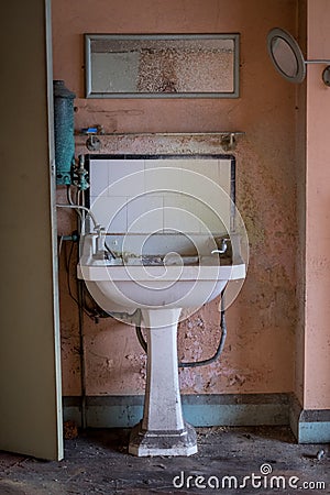 Close up of hand basin and oxidised water heater in derelict house built in 1930s deco style, Rayners Lane, Harrow UK Stock Photo