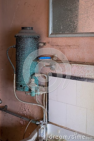 Close up of hand basin and oxidised water heater in derelict house built in 1930s deco style, Rayners Lane, Harrow UK Stock Photo