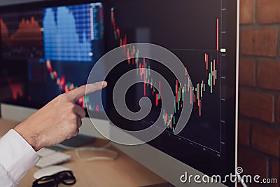 Close up of hand businessman pointing graph and analysis stock market on computer in office Stock Photo