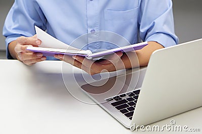 Close up hand of businessperson are opening a read book and laptop in front. Concept of data validation. Stock Photo