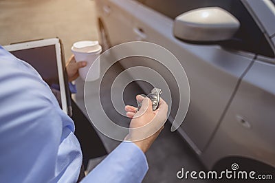 Close-up of the hand, Businesswoman opening the car door with coffee cup and laptop Stock Photo