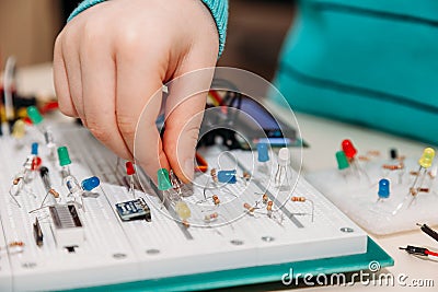 Close-up of hand of child engaged in creation of models from programmable radio parts from arduino Stock Photo