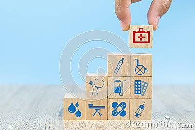 Close-up hand choose Health care and medical symbol icons on wooden toy blocks. Stock Photo