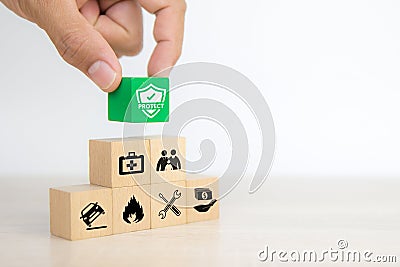 Close-up hand chooses cube wooden toy blocks stacked with prevent protect icon Stock Photo