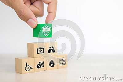 Close-up hand chooses cube wooden toy blocks stacked with prevent protect icon for safety Stock Photo