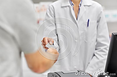 Close up of hand giving bank card to pharmacist Stock Photo