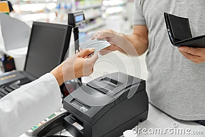 Close up of hand giving bank card to pharmacist Stock Photo