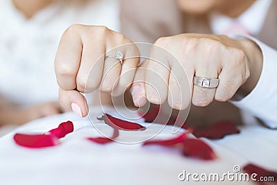 Close up hand groom couple lovers putting wear the Wedding Ring on bride Holding Stock Photo
