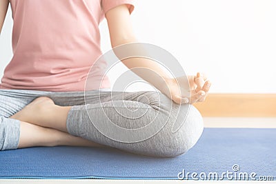 Close up hand and half body of healthy woman sit in lotus Yoga position.Young healthy woman sitting posture exercise in home. Stock Photo