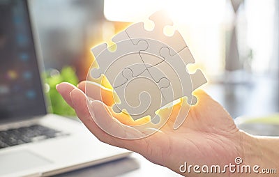 Close Up hand held jigsaw puzzle with sunlight affect Stock Photo