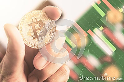 Close up hand holding bitcoin with background Candlestick chart Editorial Stock Photo