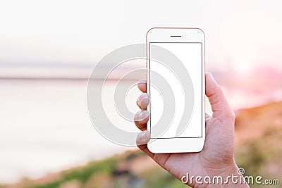 close-up hand holding phone mobile showing screen at outdoor during sunset time, mock-up new modern smartphone Stock Photo