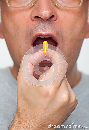Close up of hand holding a pill Stock Photo