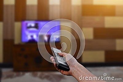 Close up hand holding remote control a television. Stock Photo