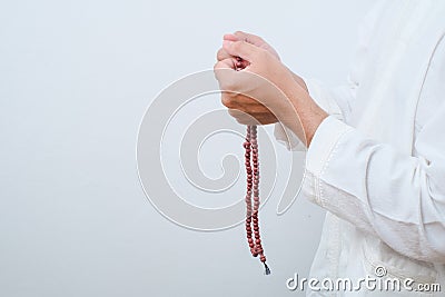 Close up Hand holding a tasbih or prayer beads Stock Photo