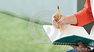 Close up hand of male teenager writing with pencil on notebook a Stock Photo